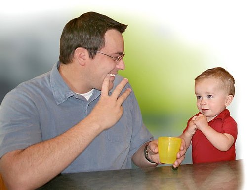 a dad signing -water- with his little boy